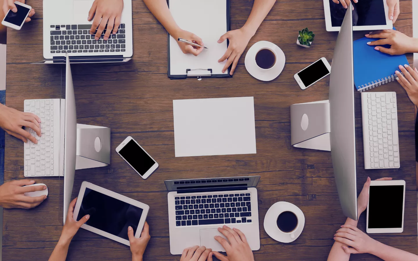 Picture of a group of founders around a table with their computers, phones and notepads beside them.